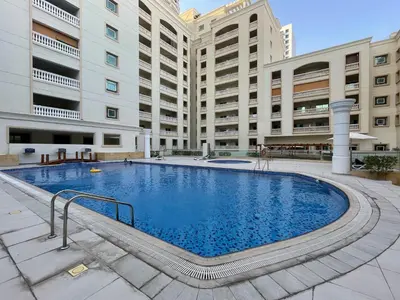 a large swimming pool in front of a building at The Smart Concierge - Plaza residences in Dubai