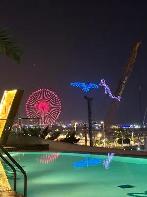 a night view of a ferris wheel and a pool at Magic JBR & Dubai marina in Dubai
