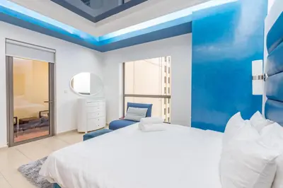 a bedroom with a white bed and a blue ceiling at Elan Rimal 5 Suites in Dubai