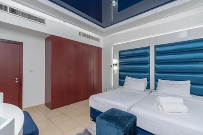 a bedroom with a large bed with a blue headboard at Elan Rimal 5 Suites in Dubai