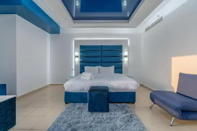 a bedroom with a blue bed and a blue chair at Elan Rimal 5 Suites in Dubai