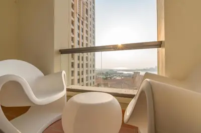 a bathroom with a white chair and a window at Elan Rimal 5 Suites in Dubai