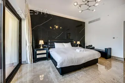 a bedroom with a large bed and a black wall at Fairmont Apartments The Palm, Free access to hotel beach and pools in Dubai