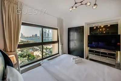 a bedroom with a bed and a large window at Fairmont Apartments The Palm, Free access to hotel beach and pools in Dubai