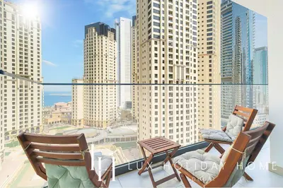 two chairs on a balcony with a view of a city at LUX Contemporary Suite with Marina View 6 in Dubai
