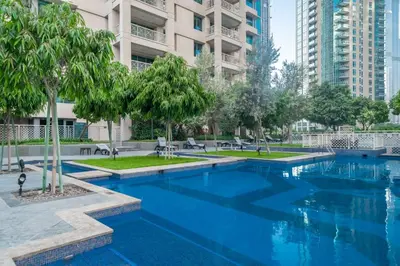 a large swimming pool with trees and buildings at BellaVista - Sophisticated - 2 BR - 29 Boulevard - Burj Khalifa & Fountain View in Dubai