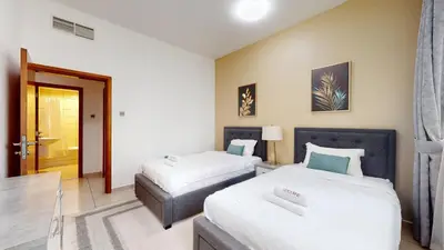 a hotel room with two beds and a table at MP12 - Luxurious 2BR in Marina Pinnacle Tower in Dubai