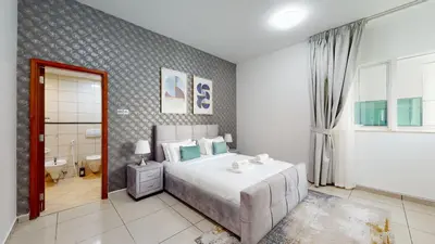 a bedroom with a large bed and a bathroom at MP12 - Luxurious 2BR in Marina Pinnacle Tower in Dubai