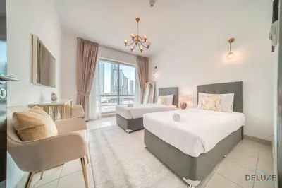 a bedroom with two beds and a couch and a chair at Classy 2BR at La Riviera Dubai Marina by Deluxe Holiday Homes in Dubai