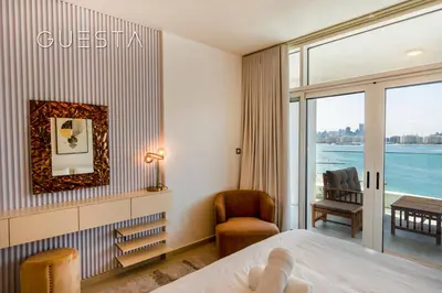 a hotel room with a bed and a chair and a window at Azizi Mina The Palm, Free beach and pool access in Dubai