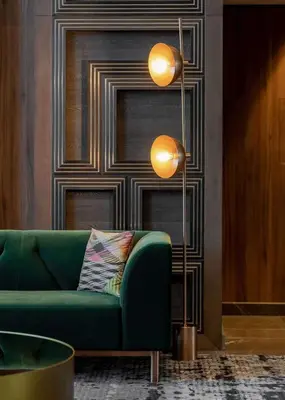 a living room with a green couch and a floor lamp at Hyatt Centric Jumeirah Dubai in Dubai