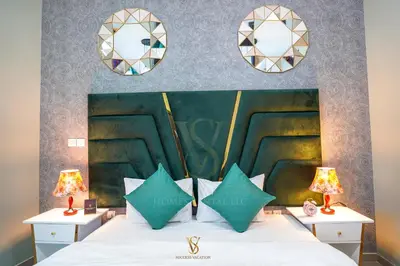 a bedroom with a bed with two lamps and two mirrors at Dubai marina , Success Luxury apartments, near JBR beach and metro station-daily free housekeeping included in Dubai
