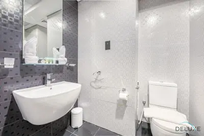 a bathroom with a white sink and a toilet at Radiant Studio at Giovanni Boutique Suites DSC by Deluxe Holiday Homes in Dubai