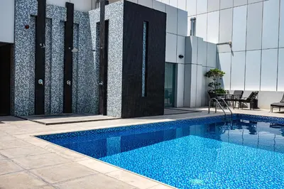 a swimming pool in front of a building at Radiant Studio at Giovanni Boutique Suites DSC by Deluxe Holiday Homes in Dubai
