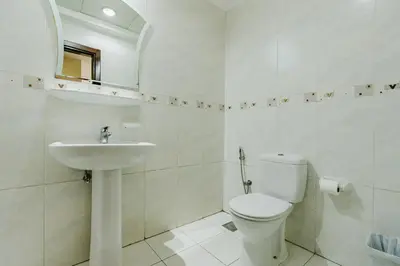 a white bathroom with a toilet and a sink at RH- Modern Urban Oasis, Spacious 02RB near mall of Emirates in Dubai