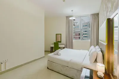 a white bedroom with a bed and a window at RH- Modern Urban Oasis, Spacious 02RB near mall of Emirates in Dubai