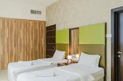 two beds in a room with green and white at RH- Modern Urban Oasis, Spacious 02RB near mall of Emirates in Dubai