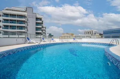 a swimming pool on the roof of a building at RH- Modern Urban Oasis, Spacious 02RB near mall of Emirates in Dubai