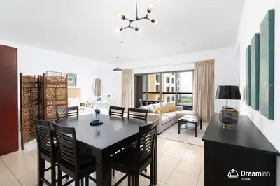 a dining room and living room with a black table and chairs at Dream Inn Apartments - Rimal JBR in Dubai