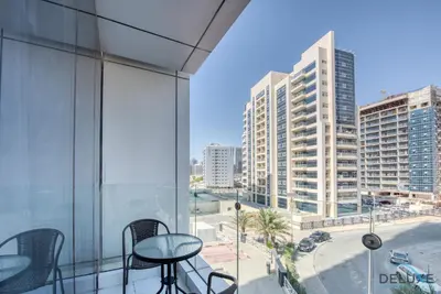 a balcony with chairs and a view of a city at Captivating Studio at Giovanni Boutique Suites DSC by Deluxe Holiday Homes in Dubai