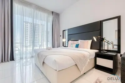 a bedroom with a large bed and a large window at Captivating Studio at Giovanni Boutique Suites DSC by Deluxe Holiday Homes in Dubai