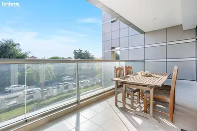 a dining room with a table and chairs on a balcony at bnbmehomes - The Medalist in Dubai