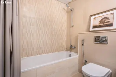 a bathroom with a bath tub and a toilet at bnbmehomes - The Medalist in Dubai