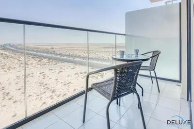a table and chairs on a balcony with a view of the beach at Restful Studio at Celestia A Dubai South by Deluxe Holiday Homes in Dubai