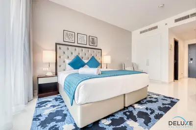 a bedroom with a large bed and a blue rug at Restful Studio at Celestia A Dubai South by Deluxe Holiday Homes in Dubai