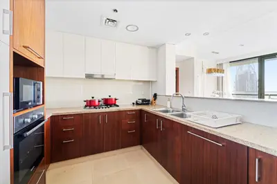 a kitchen with white cabinets and red pots on the stove at Luxury 2BR Skyline Sea View Direct Mall Metro Dining Shops City Walk in Dubai