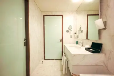 a bathroom with a sink and a shower and a mirror at Emaar Fashion Avenue one bedroom - Formerly Address Dubai Mall Four Apple Holiday Homes in Dubai