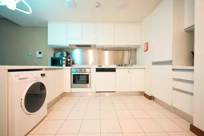 a kitchen with white cabinets and a dishwasher at Emaar Fashion Avenue one bedroom - Formerly Address Dubai Mall Four Apple Holiday Homes in Dubai