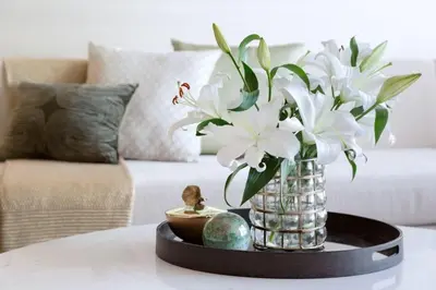 a vase with white flowers on a table in a living room at HVR THE PALM DUBAI in Dubai