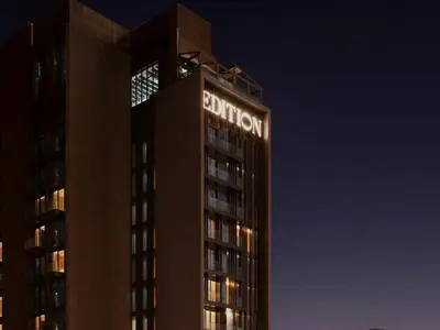 a tall building with a hotel sign on top at night at The Dubai EDITION in Dubai