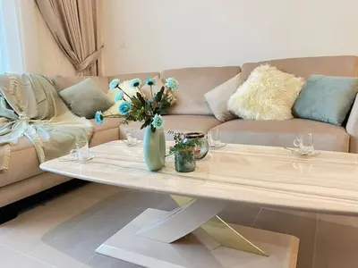 a living room with a couch and a table with flowers at Elite Inn: Parkridge904 in Dubai
