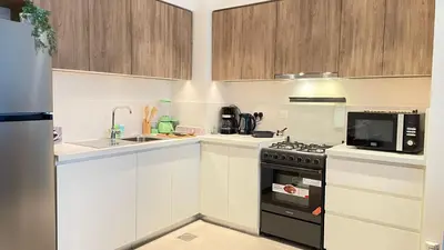 a small kitchen with a stove and a microwave at Elite Inn: Parkridge904 in Dubai