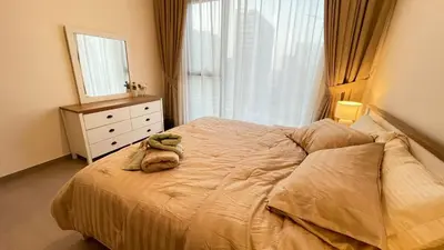 a bedroom with a bed with a dresser and a window at Elite Inn: Parkridge904 in Dubai