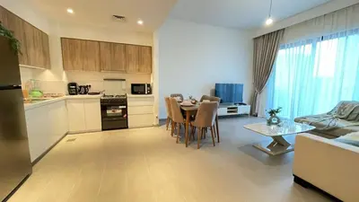 a kitchen and living room with a table and a couch at Elite Inn: Parkridge904 in Dubai