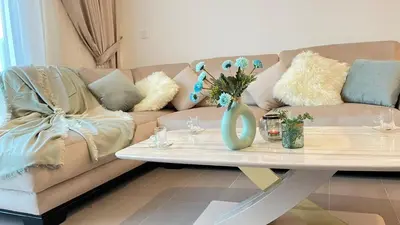 a living room with a couch and a table with flowers at Elite Inn: Parkridge904 in Dubai
