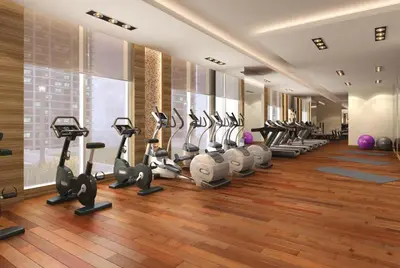 a gym with a row of treadmills and ellipticals at Immaculate Studio at DAMAC Celestia by Deluxe Holiday Homes in Dubai