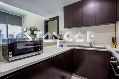 a kitchen with a microwave and a sink at Staycae Holiday Homes - Merano in Dubai