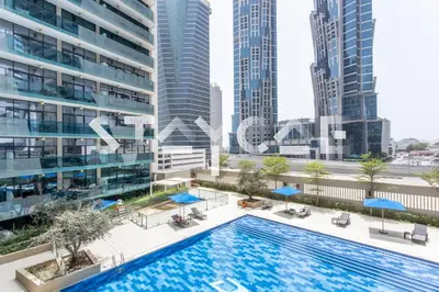 a swimming pool on the roof of a building with tall buildings at Staycae Holiday Homes - Merano in Dubai