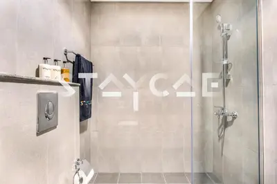 a bathroom with a shower with a glass door at Staycae Holiday Homes - Merano in Dubai