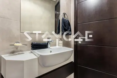 a bathroom with a white sink next to a door at Staycae Holiday Homes - Merano in Dubai