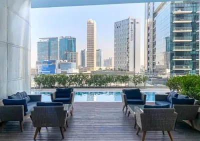 a patio with chairs and a pool in a city at Modern 1BR Apartment, High Floor, Near Dubai Mall in Dubai