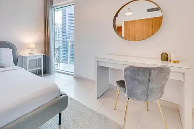 a bedroom with a bed and a desk and a mirror at Great views from New apartment in Dubai Marina in Dubai