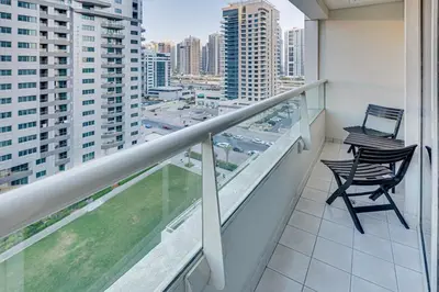 two chairs on a balcony with a view of a city at Great views from New apartment in Dubai Marina in Dubai