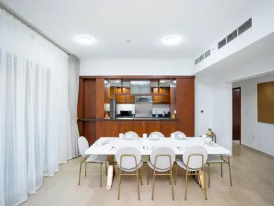 a dining room with a white table and chairs at Holidays R Us villa 3 bedroom premium location in Dubai