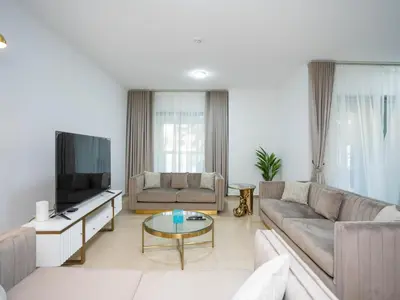 a living room with a couch and a tv at Holidays R Us villa 3 bedroom premium location in Dubai