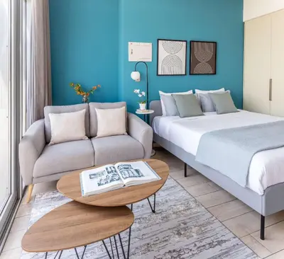 a bedroom with a bed and a couch and a table at Silkhaus elegant studio with Burj Khalifa view and balcony in Dubai